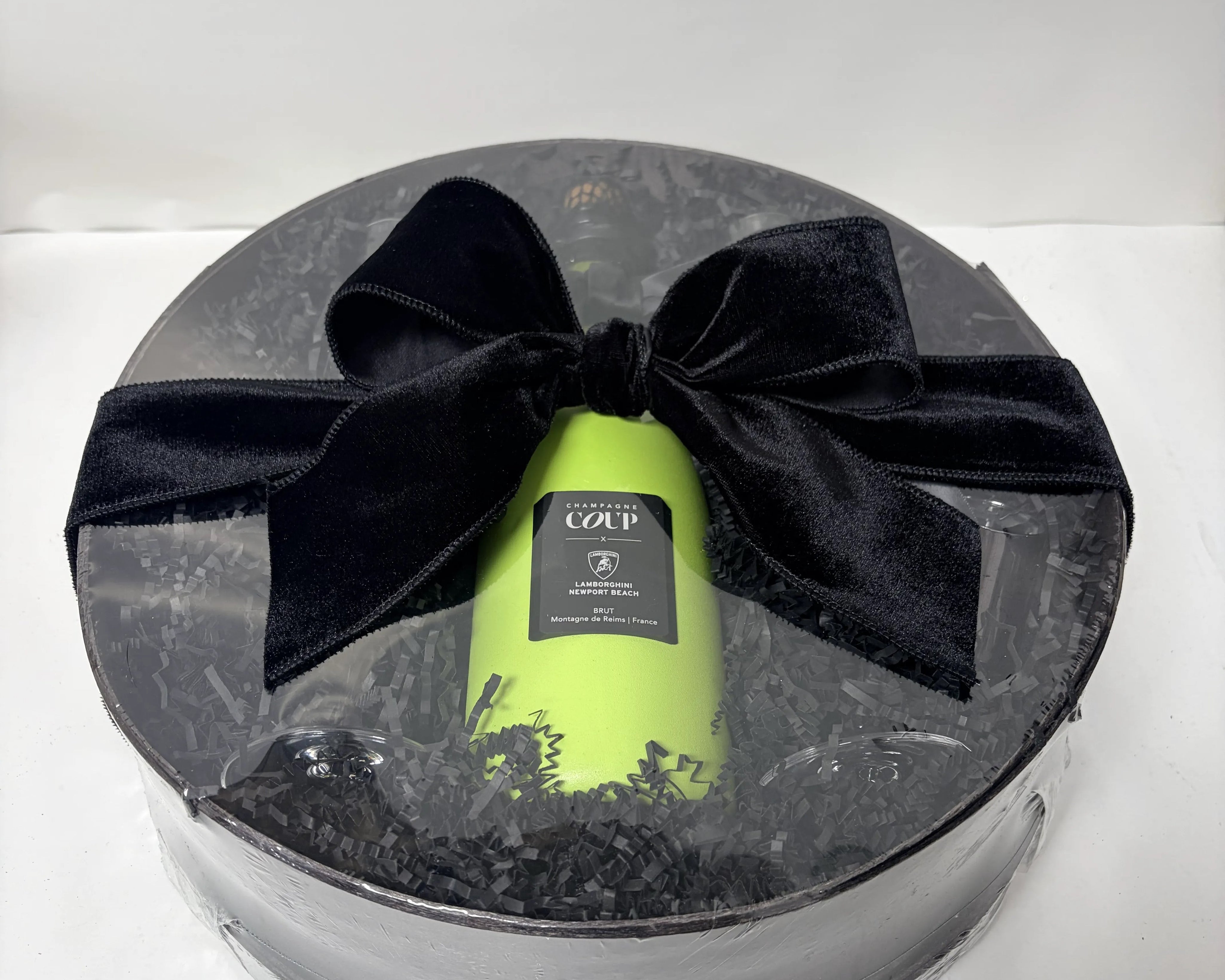 Champagne bottle in a briefcase beside the finished gift basket built around it, Nifty Package Co