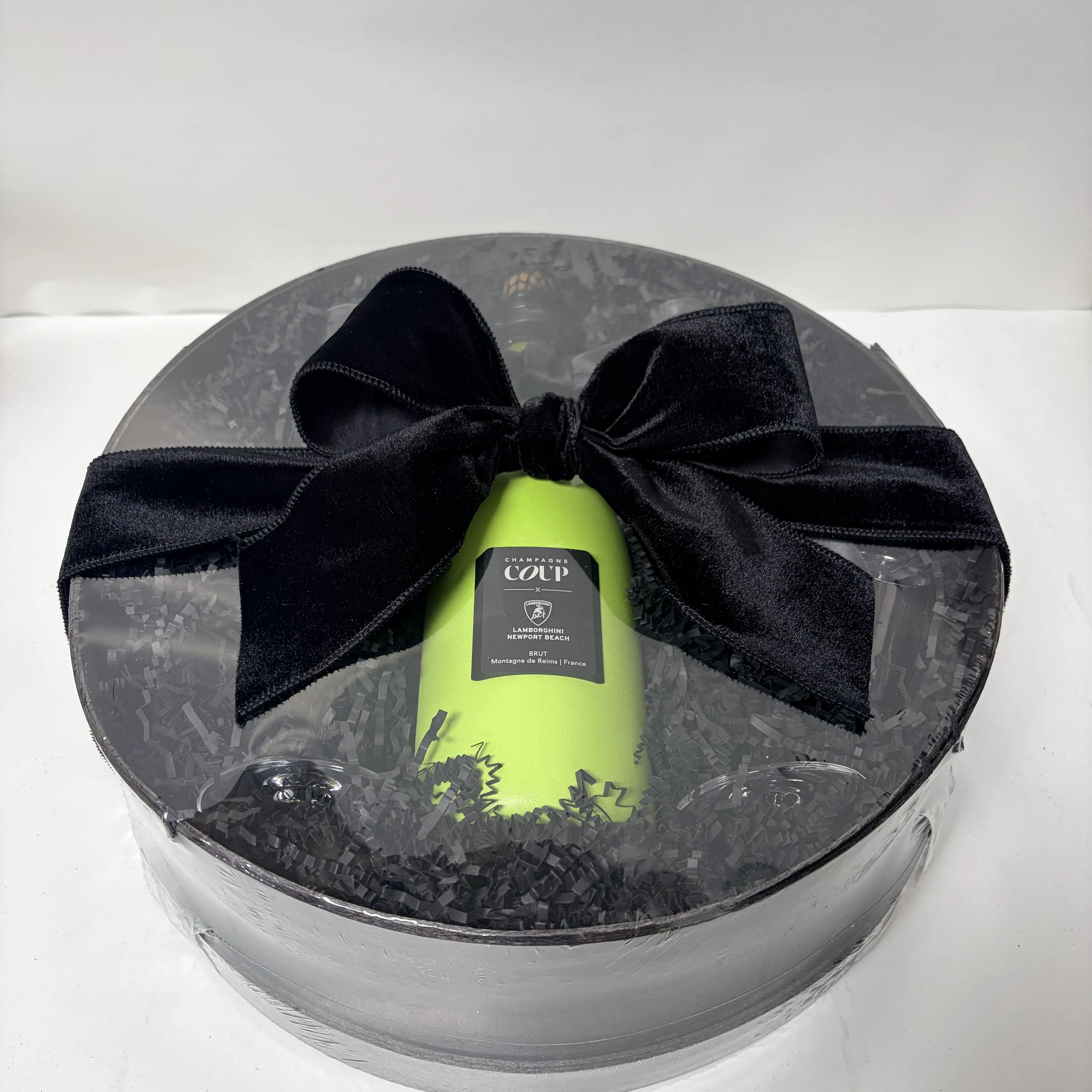 Champagne bottle in a briefcase beside the finished gift basket built around it, Nifty Package Co