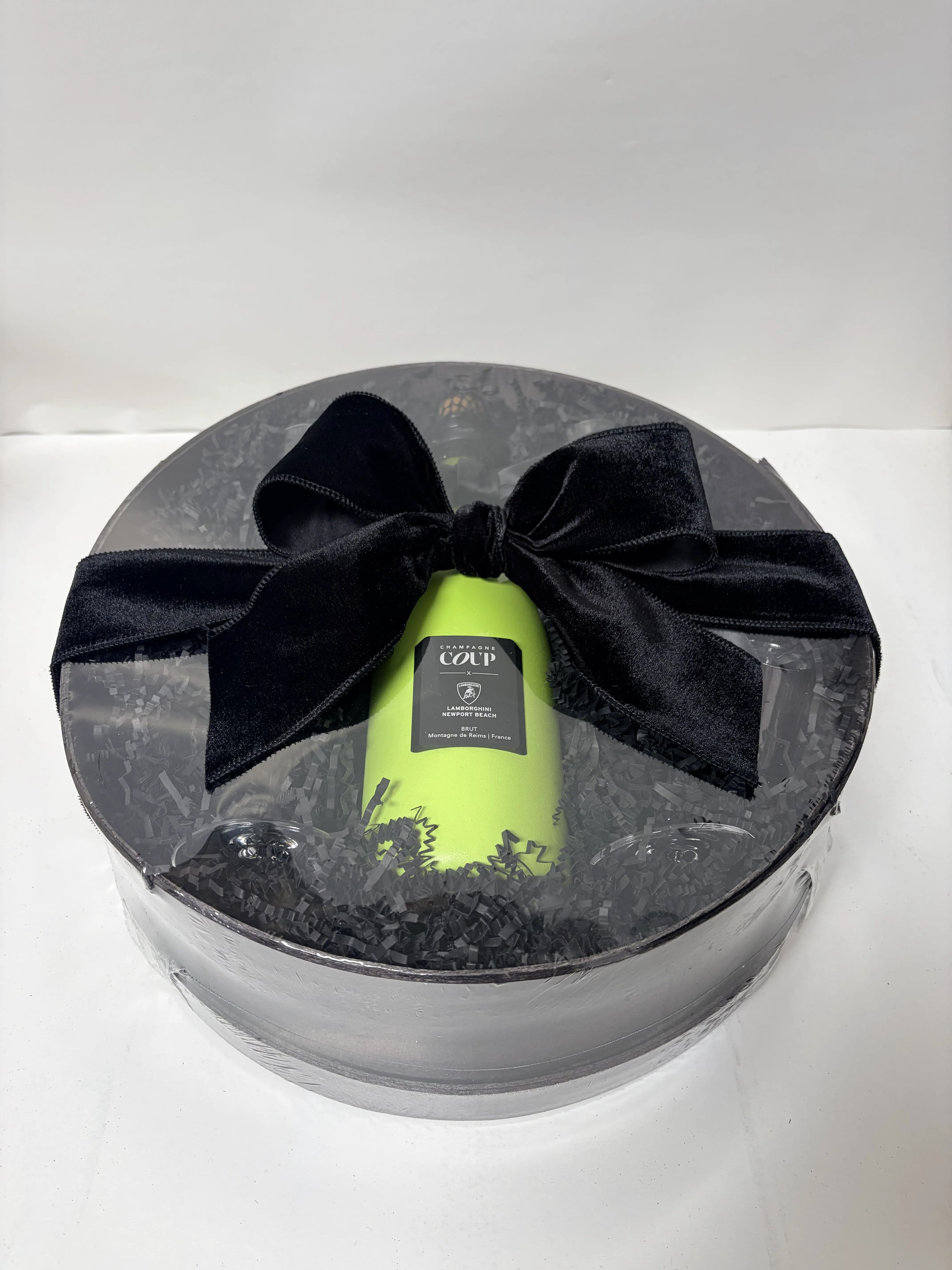 Champagne bottle in a briefcase beside the finished gift basket built around it, Nifty Package Co
