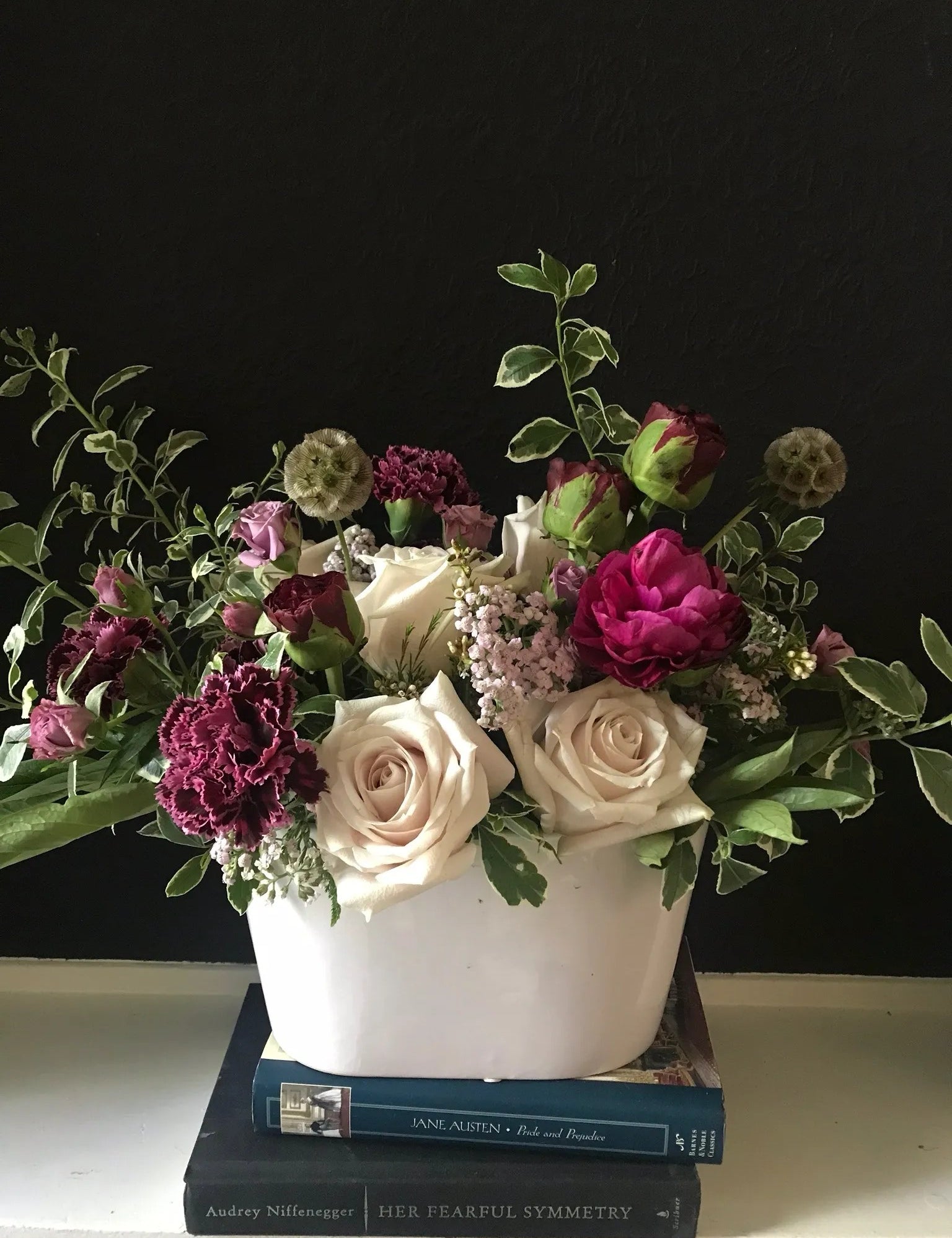 Romantic Garden luxury floral arrangement featuring deep fuchsia ranunculus, plum luxury carnations, and soft ivory roses in a modern white ceramic vessel by Nifty Package Co