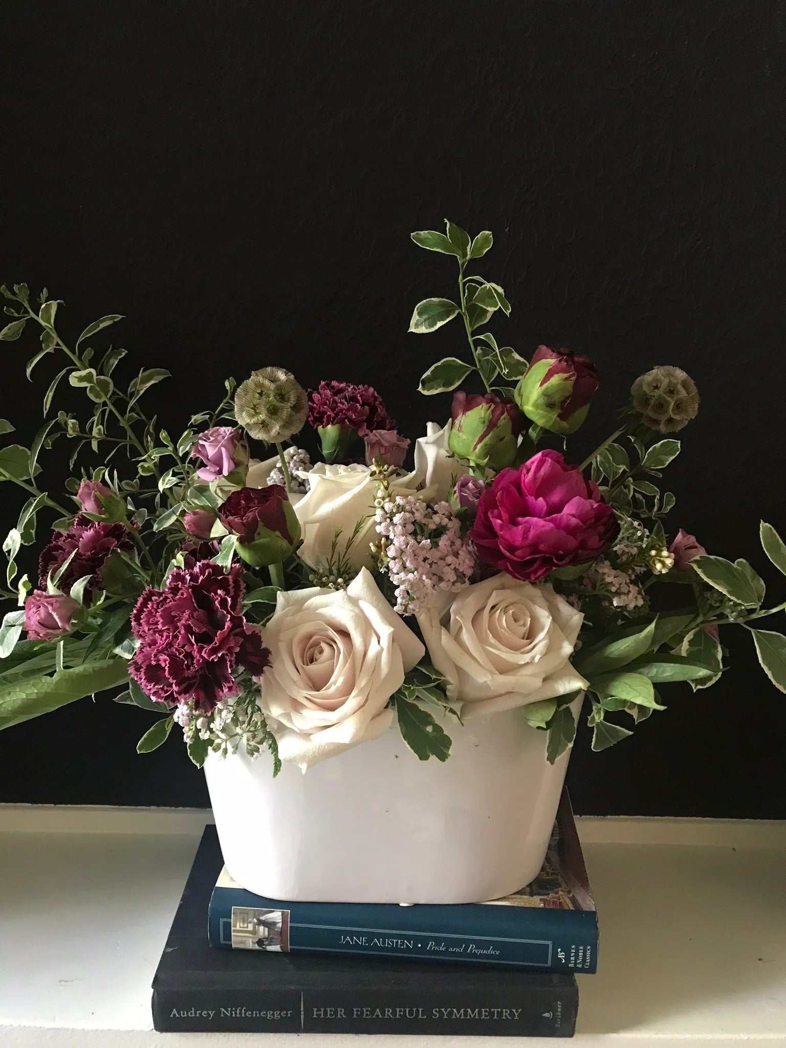 Romantic Garden luxury floral arrangement featuring deep fuchsia ranunculus, plum luxury carnations, and soft ivory roses in a modern white ceramic vessel by Nifty Package Co